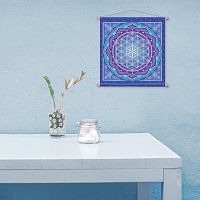 Minimalist scene evoking tranquility, an almost bare tabletop, and the Flower of Life banner hanging on a pale blue wall.