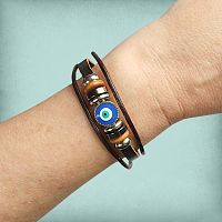 Evil Eye Leather Bracelet worn on a wrist, showing the vibrant blue and white evil eye charm, flanked by metal and wood beads