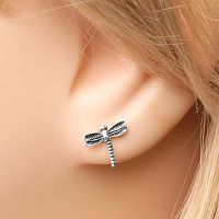 Closeup of a sterling silver dragonfly post earring in a model's ear, highlighting the subtle texturing on the dragonfly wings.
