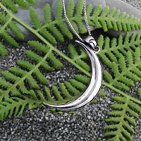 Sterling Silver Lunar Magic Pendant rests gently on a fern frond backdrop, for a delightful blend of nature and artistry.