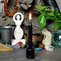 A lit black chime candle, in a personal altar display, showing how it might be used in a ritual or ceremonial setting.