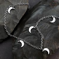 Silver-colored stainless steel anklet with a cable style chain draped over rocks, featuring five crescent moon charms.