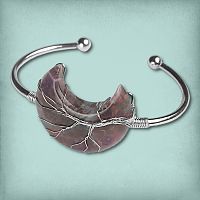 Wire-Wrapped Amethyst Moon Bracelet with a tree motif on a purple gemstone crescent, secured to a silver-tone cuff.