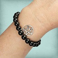 Black Agate Pentacle Charm Bracelet on a wrist, displaying its snug but comfortable fit thanks to the elastic cord