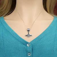 Sterling Silver Thor's Hammer Pendant, is being worn on a silver chain around a woman's neck, showing that it is unisex.