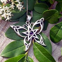 Silver Celtic Butterfly Pendant on a backdrop of leaves and spring flowers, showing its graceful and artistic design.