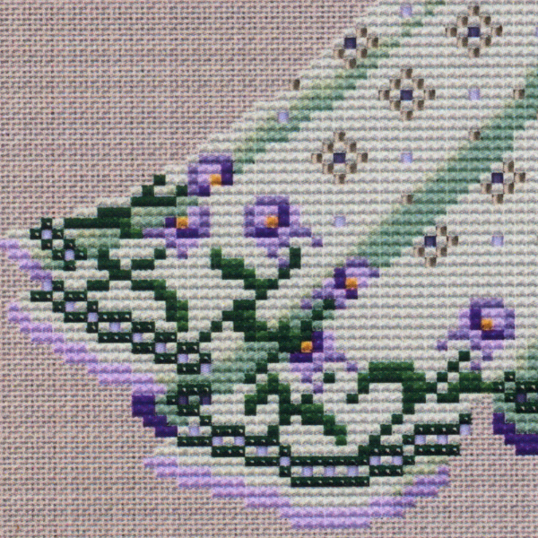 Close-up of the Dance of the Vernal Equinox cross stitch design, showing the gown's floral hem with lavender and green tones.